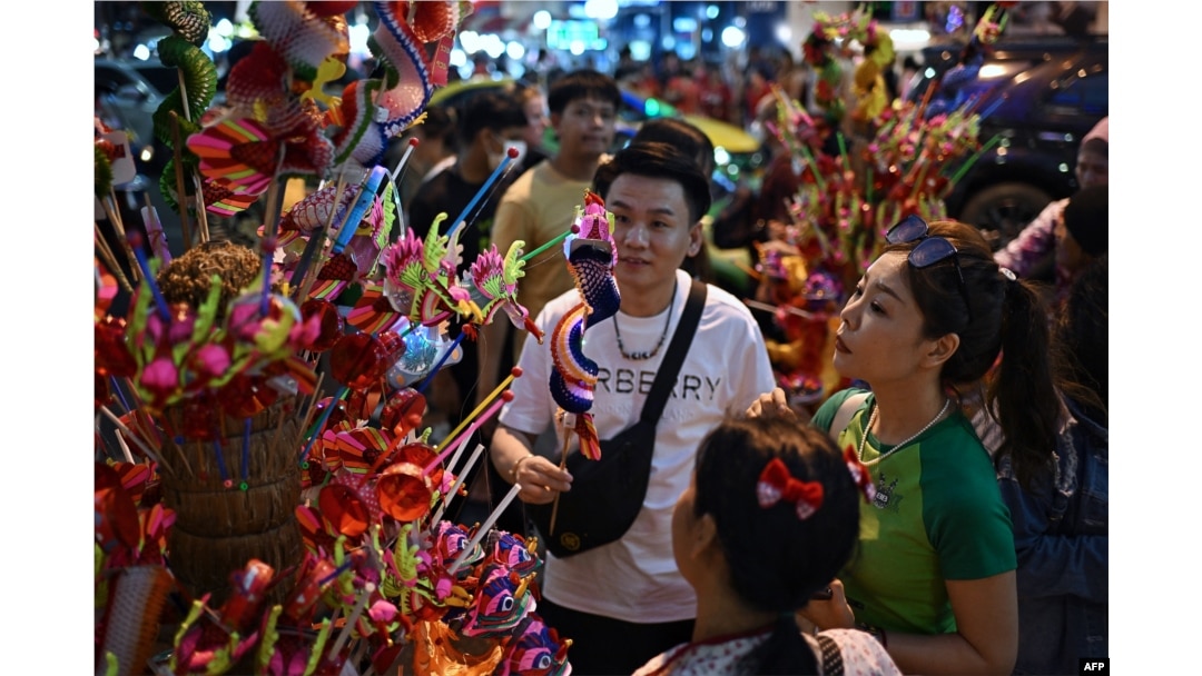 People buy dragon puppets on Yaowarat Road in Bangkok's Chinatown on Feb. 9, 2024, on the eve of the Lunar New Year.