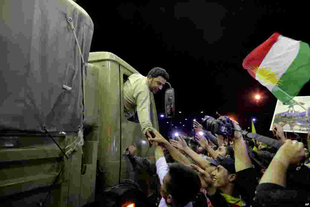 Kurd peshmerga jangchisi Kobaniga yo'l olish oldidan mahalliy aholi bilan xayrlashmoqda, Iroq, 29-oktabr, 2014-yil.
