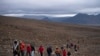 People climb to the top of what once was the Okjokull glacier, in Iceland, Aug. 18, 2019.