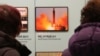 Visitors watch a photo showing North Korea's missile launch at the Unification Observation Post in Paju, South Korea, near the border with North Korea, Dec. 13, 2019. 