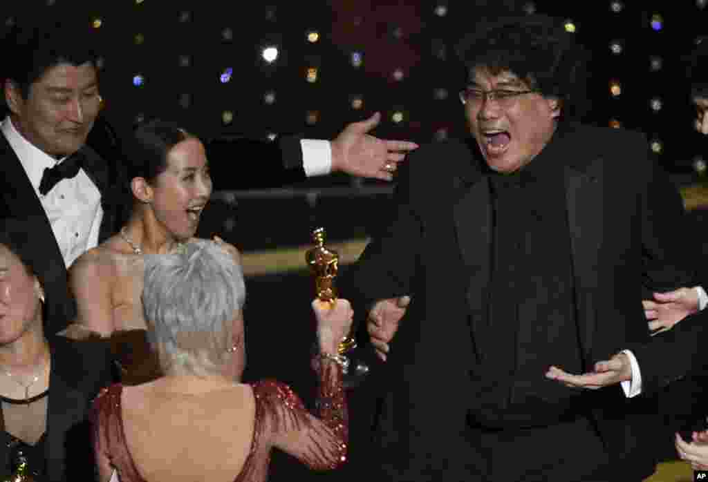 Bong Joon Ho, right, reacts as he is presented with the award for best picture for "Parasite" from presenter Jane Fonda at the Oscars, Feb. 9, 2020, at the Dolby Theatre in Los Angeles, California.