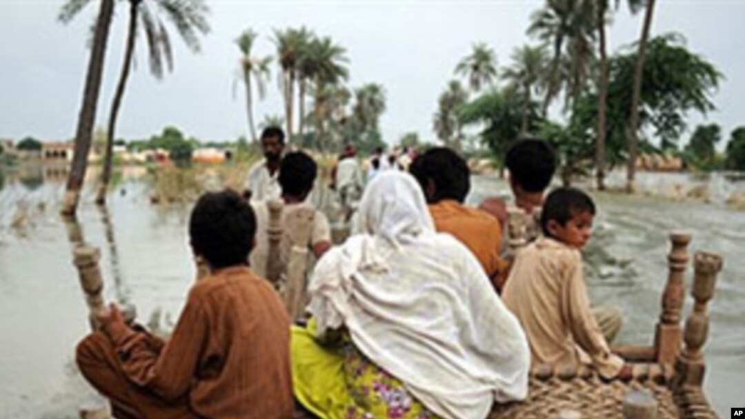 Pakistani villagers make their way through flood waters in Baseera, Pakistan, 24 Aug 2010