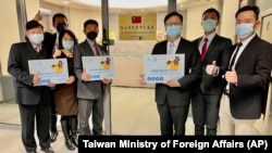 FILE - Eric Huang, newly appointed director to the representative office, third from right, poses with other staffers outside the Taiwan Representative Office in Vilnius, Lithuania, Nov. 18, 2021.