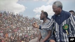 Then-African National Congress President Nelson Mandela salutes the crowd in Galeshewe Stadium near Kimberley, South Africa, Feb. 25, 1994. 