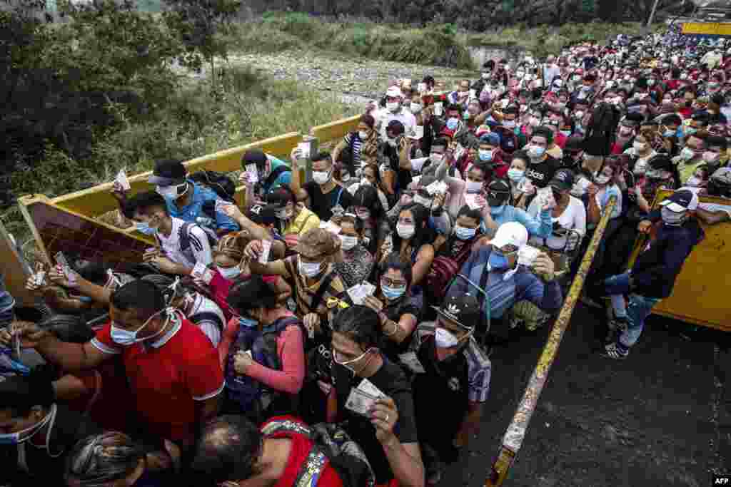 People coming from Venezuela with protective face masks as a precautionary measure to avoid contracting the new coronavirus, COVID-19, show hold their documents on the border at Simon Bolivar International Bridge, in Cucuta, Colombia.
