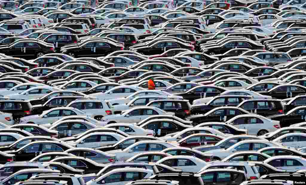 Seorang pekerja berjalan di antara mobil-mobil Mercedes yang siap diangkut dengan kapal di pelabuhan Bremerhaven, Jerman.