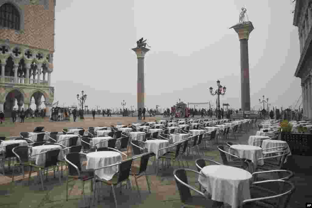 Empty tables sit in St. Mark's square in Venice, Italy. Italy has been scrambling to check the spread of Europe's first major outbreak of the new viral disease amid rapidly rising numbers of infections and calling off the popular Venice Carnival and closing tourist attractions.