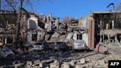 This photograph taken on Nov. 25, 2024 shows damaged cars in the courtyard of a destroyed building following a missile attack in Odesa.