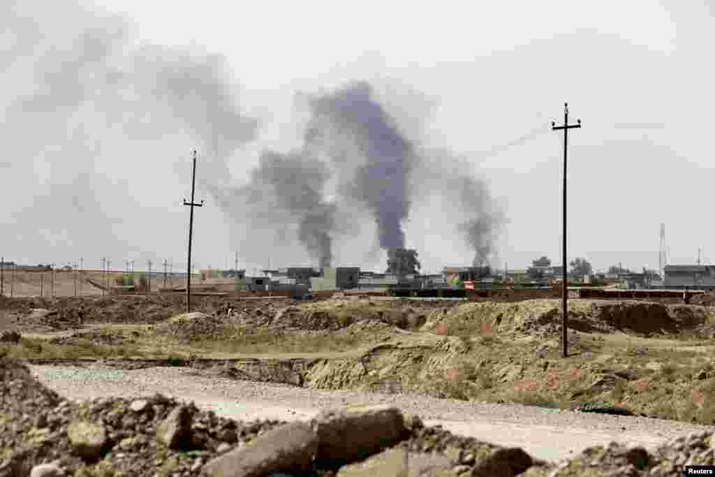 Smoke rises from Sulaiman Bek after fighters of the Asaib Ahl al-Haq Shi'ite militia from the south of Iraq and Kurdish peshmerga forces took control of the town from Islamist State militants, in the northwest of Tikrit city, Sept. 1, 2014.