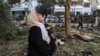 FILE - A woman reacts while holding a pillow as she stands amidst debris outside the site of the Ahli Arab Hospital in central Gaza on Oct. 18, 2023, in the aftermath of an overnight strike there.