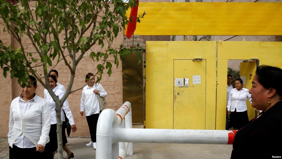 FILE - Ethnic Uighur women leave a center where political education lessons are held in Kashgar, in Xinjiang Uighur Autonomous Region, China, Sept. 6, 2018.