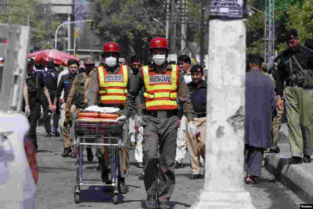 Rescue workers transport body parts of blast victims from the site of a bomb attack in Peshawar, Pakistan, March 29, 2013.