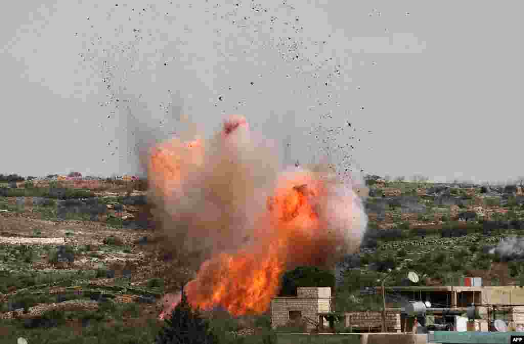 An explosion is seen following Russian airstrikes on the village of al-Bara in the southern part of Syria's northwestern Idlib province.