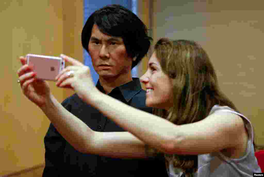 Seorang perempuan mengambil foto selfie dengan robot manusia HI-4, di Duesseldorf, Jerman.