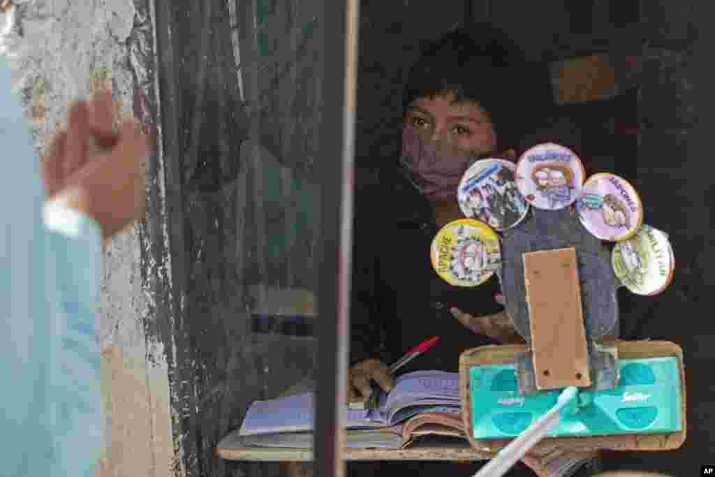 Eleven-year-old Oscar Rojas listens to his teacher Gerardo Ixcoy, outside Oscar's home in Santa Cruz del Quiche, Guatemala.