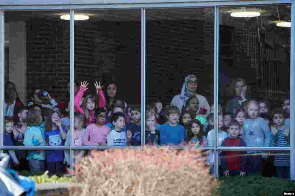 Students watch from a window as Democratic 2020 U.S. presidential candidate and U.S. Senator Elizabeth Warren (D-MA) arrives to vote on Super Tuesday in Cambridge, Massachusetts.