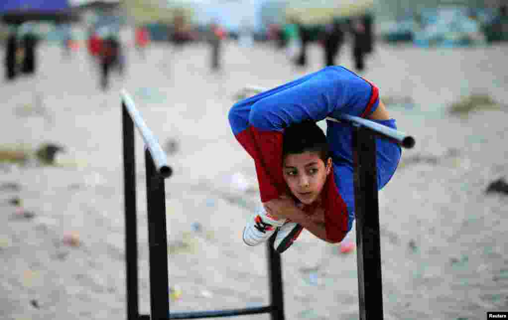 Seorang anak Palestina, Mohamad al-Sheikh (12 tahun), yang dijuluki 'Spiderman', menunjukkan kemampuan akrobatiknya di sebuah pantai di Gaza City.