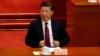 Chinese President Xi Jinping adjusts his jacket during the opening session of the Chinese People's Political Consultative Conference (CPPCC) was held in Beijing, China, March 3, 2017. 