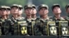 Binh sĩ Bắc Triều Tiên cầm ba lô in biểu tượng hạt nhân nhìn về phía lãnh tụ Kim Jong Un trong một buổi lễ kỷ niệm 60 năm hiệp ước đình chiến chấm dứt Chiến tranh Triều Tiên, ở Bình Nhưỡng, 27/7/2013.