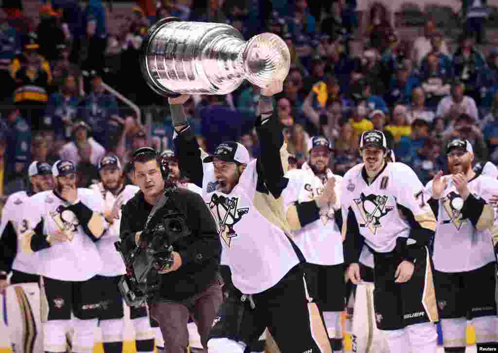 Pemain hoki es Pittsburgh Penguins Matt Cullen (7) mengangkat piala Stanley Cup setelah timnya mengalahkan tim San Jose Sharks di San Jose, California.