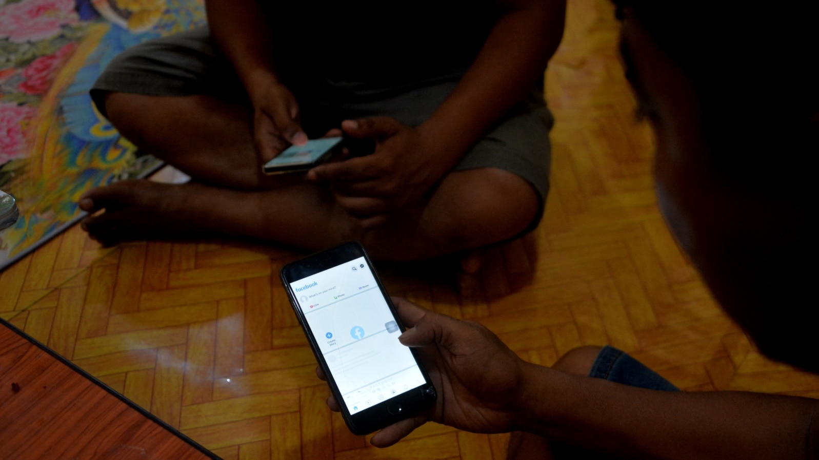 FILE - Young men use their mobile phones in Naypyidaw on March 16, 2021, as Myanmar military authorities ordered telecommunication companies to restrict services on their mobile data networks.