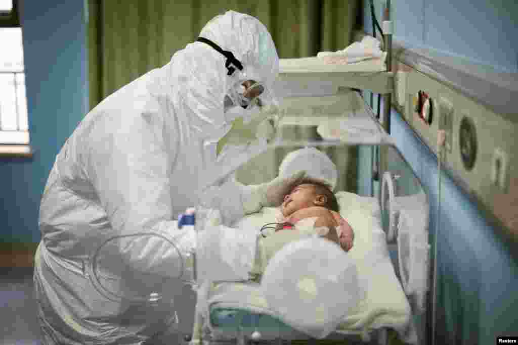 A medical staff attends to a baby with novel coronavirus at the Wuhan Children’s Hospital, in Wuhan, the epicenter of the outbreak, in Hubei province, China.