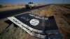 A black sign belonging to Islamic State militants is seen on the road in Al-Al-Fateha military airport south of Hawija, Iraq, Oct. 2, 2017.