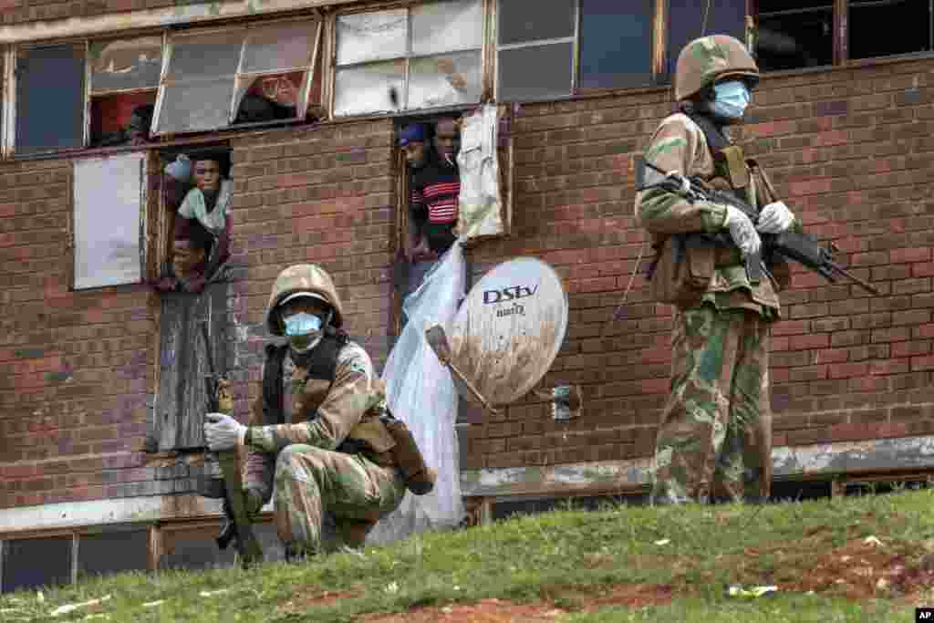 South African National Defense Forces patrol the Men's Hostel in the densely populated Alexandra township east of Johannesburg, March 28, 2020, enforcing a strict lockdown in an effort to control the spread of the coronavirus.